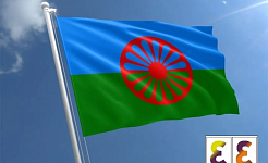 Η σημαία των Ρομά με το λογότυπο της ΕΕΔΑ στη γωνία της εικόνας