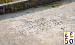 Στιγμιότυπο από το σπότ της ΕΕΔΑ (γραμμένο σε ταράτσα με σπρέυ: Ελευθερία, Αξιοπρέπεια, Δικαιοσύνη)